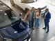Car dealership sales manager speaking with potential car buyers