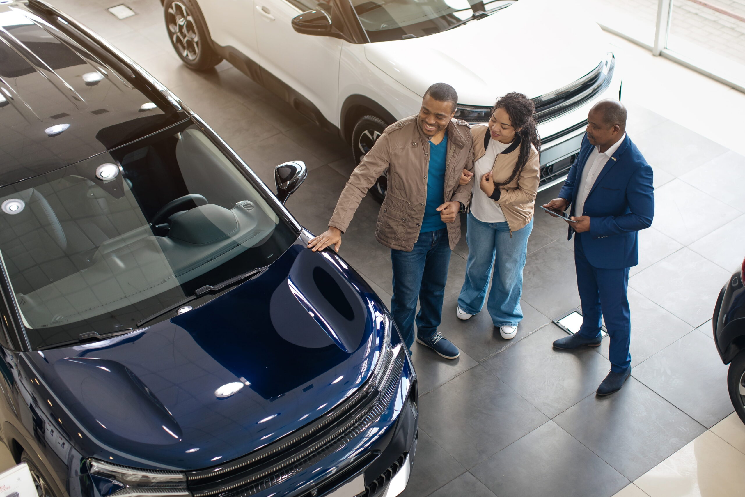 Car dealership sales manager speaking with potential car buyers
